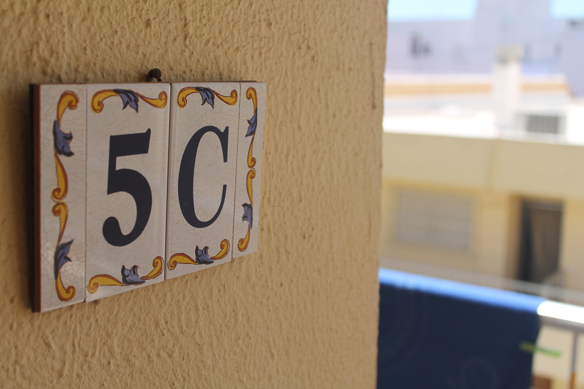 Keramik-Kachel mit der Wohnungsnummer 5C am Eingang der Casa